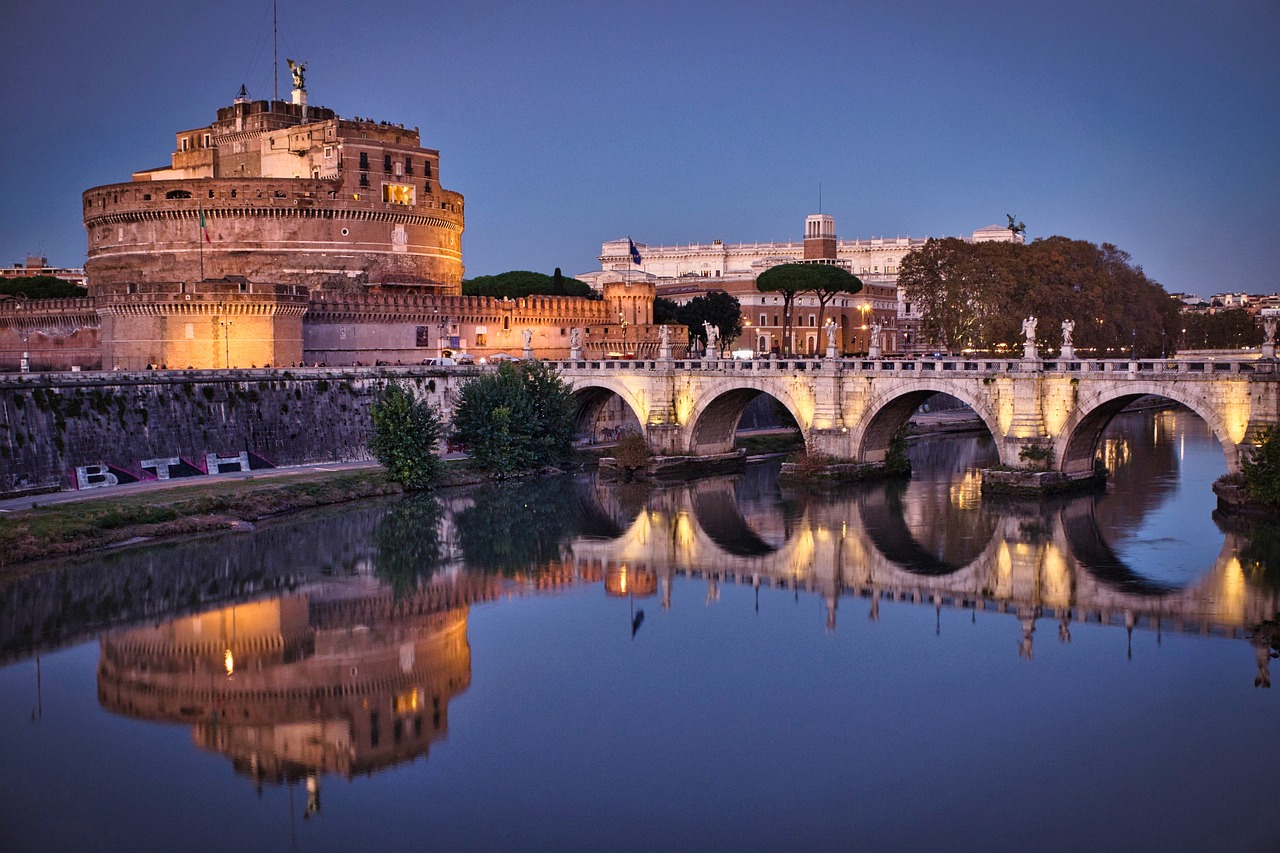 The Castel Sant'Angelo at dusk with the bridge reflecting on the Tiber River in Rome